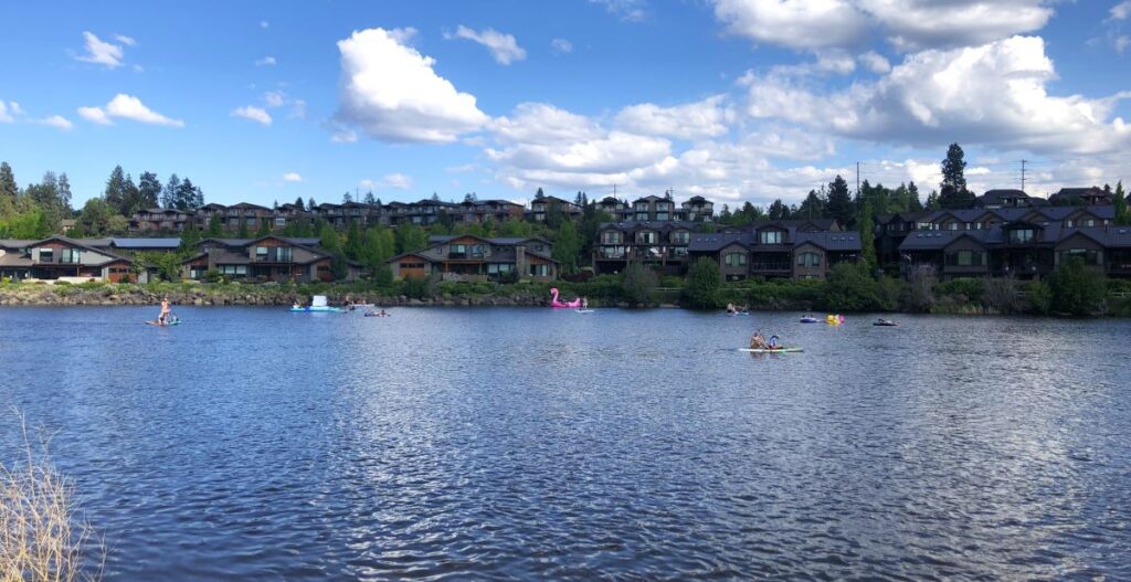 People on the Deschutes River kayaking and paddleboarding in Bend. 