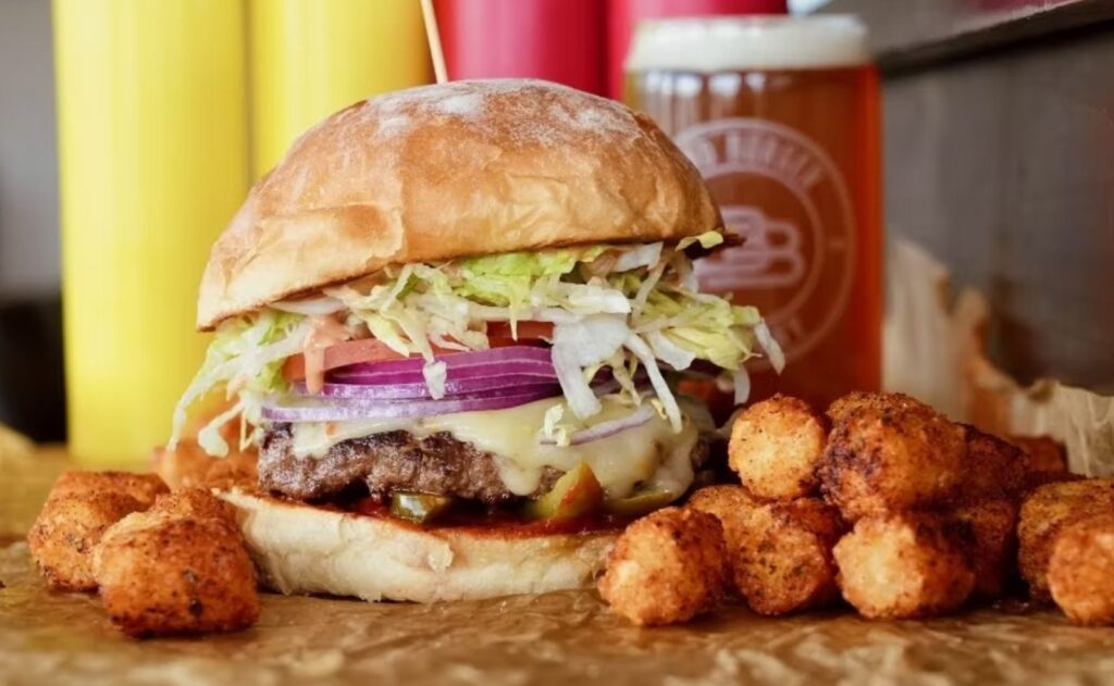 A burger with tater tots from Bend Burger Company, one of the best burgers in Bend.