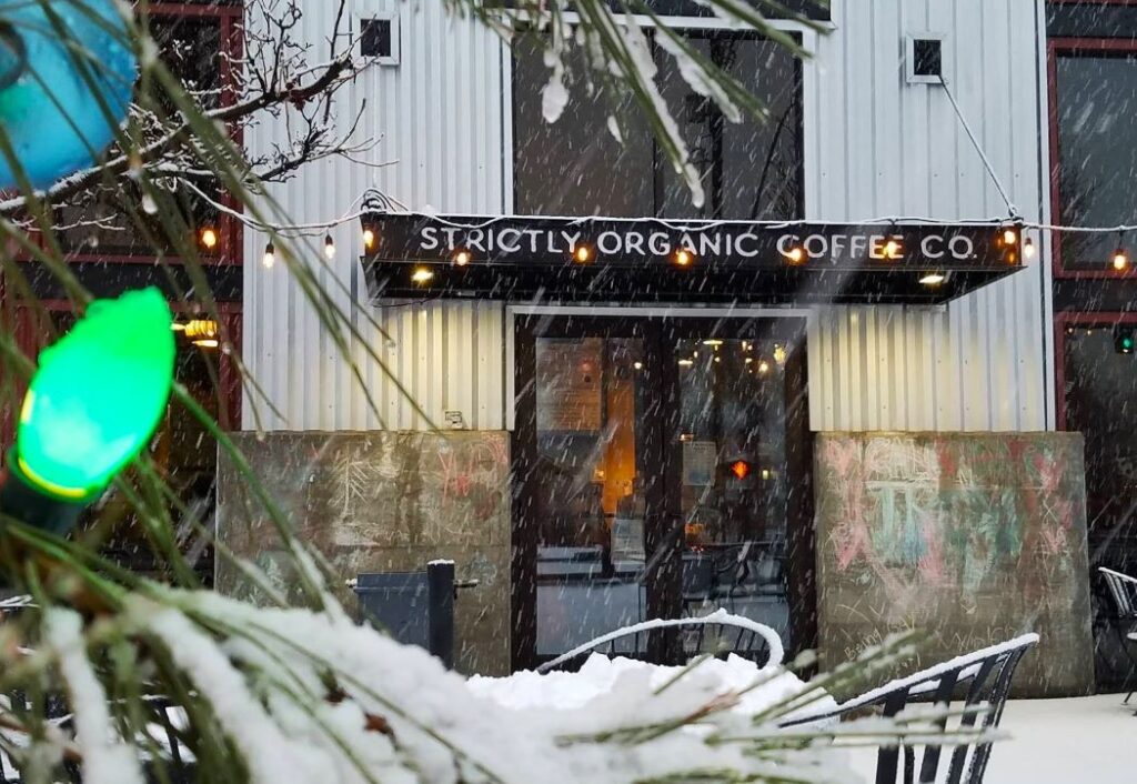 The entrance to Strictly Organic coffee shop in Bend on a festive snowy day.