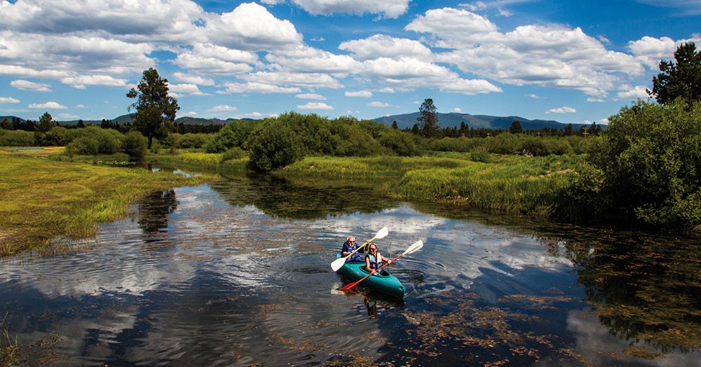 People kayaking at Bend Sunriver Thousand Trails, one of best RV parks Bend Oregon has to offer.