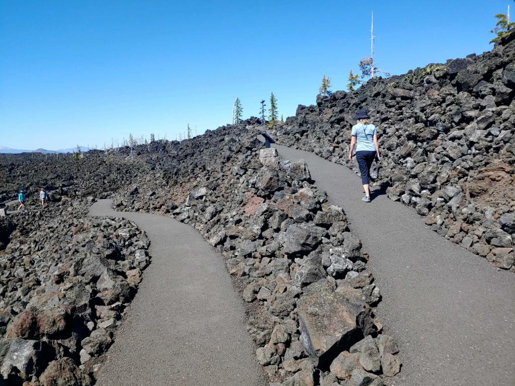 A visitor hiking a trail at Belknap Crater