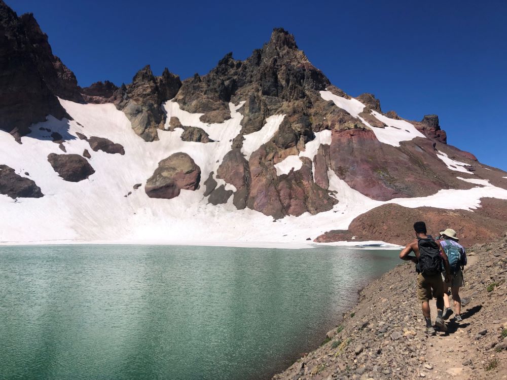 Hikers arriving at No Name Lake on a sunny day.