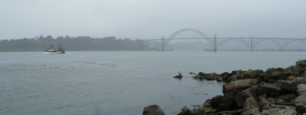 A boat passes under the Yaquina Bay Bridge in Newport Oregon.