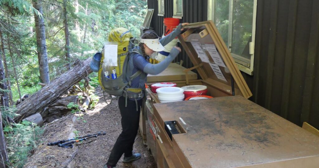 Abby picking up our food cache on the Wonderland Loop Trail.