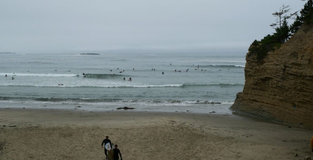 People surfing the waves at Otter Rock Beach.