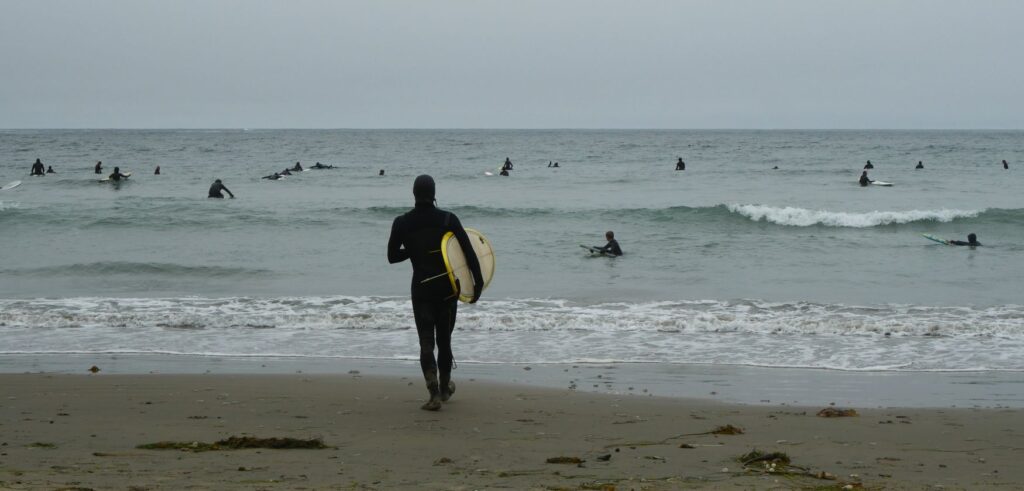 Logan going out to surf at Otter Rock.