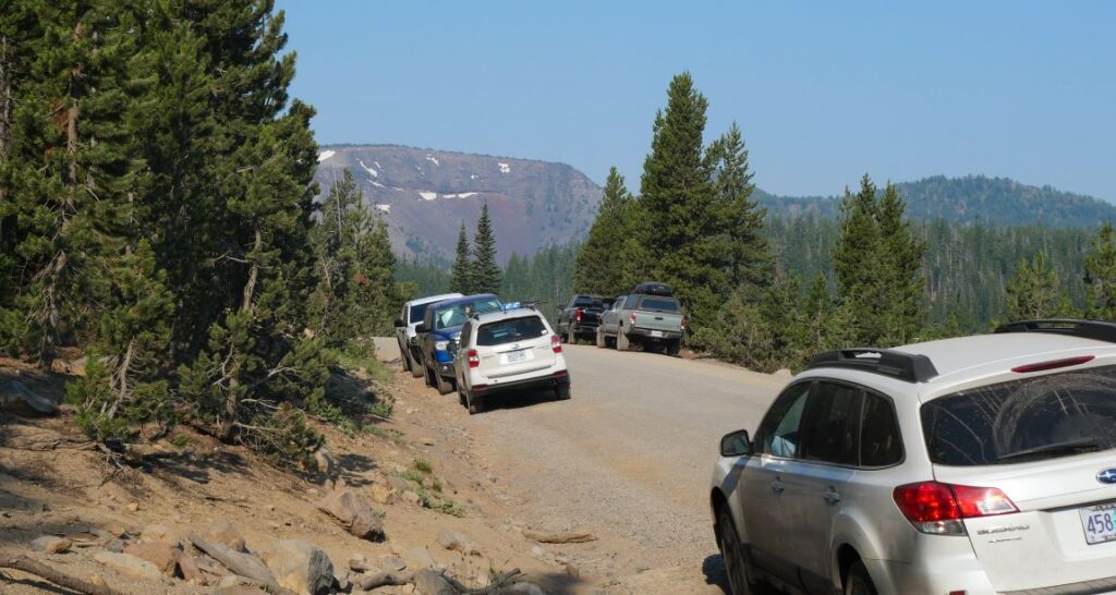 Cars parked at the Tam McArthur Rim Trailhead near Three Creek Lake.