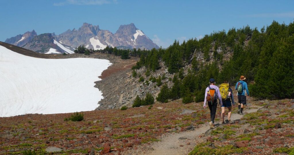 Hikers following the Tam McArthur Trail with Broken Top in the background.