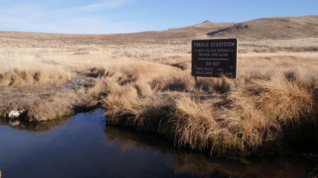 Signage bordering one of the undeveloped pools at Hart Mountain Hot Springs.